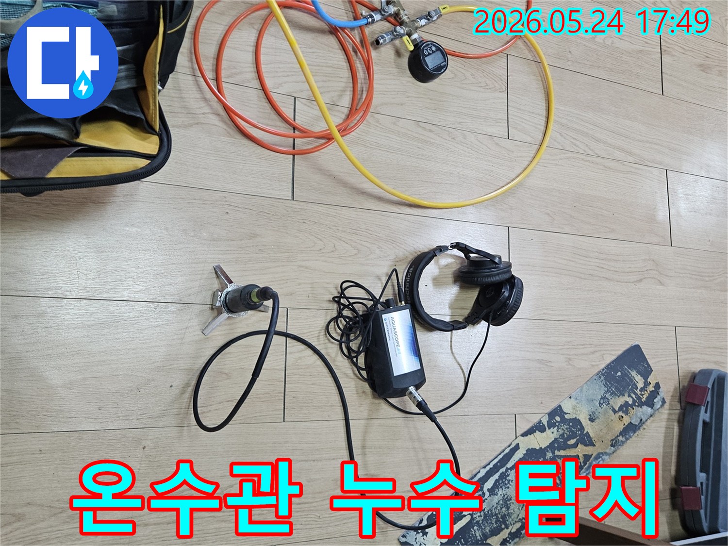온수관 누수 탐지를 위해-전문 엔지니어가-압력 주입 장치와-청음식 센서를 연결하여-작업을 진행하고 있습니다.