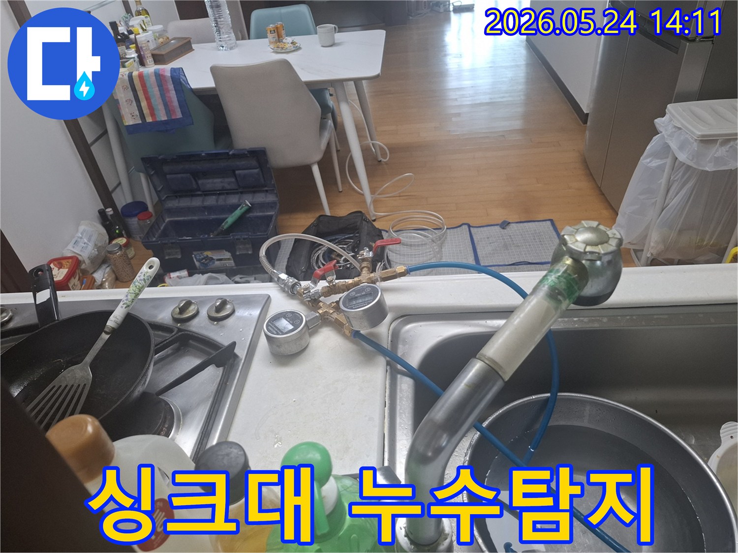 싱크대에서 누수 탐지 장비를 연결하여 배관 상태를-정밀하게-점검하는-모습입니다