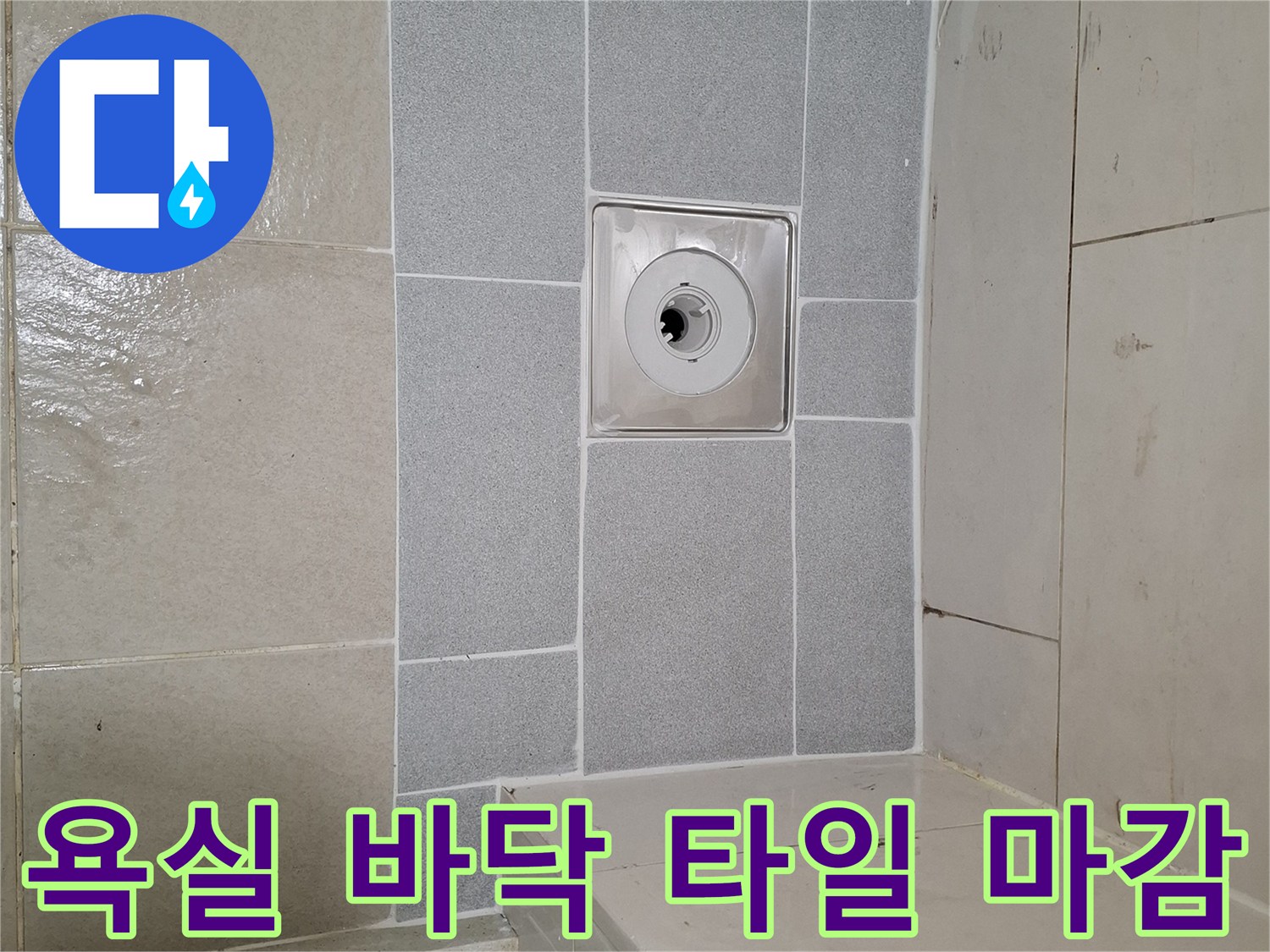 배수구 주변의 깨끗한 타일 시공 완료 사진입니다.