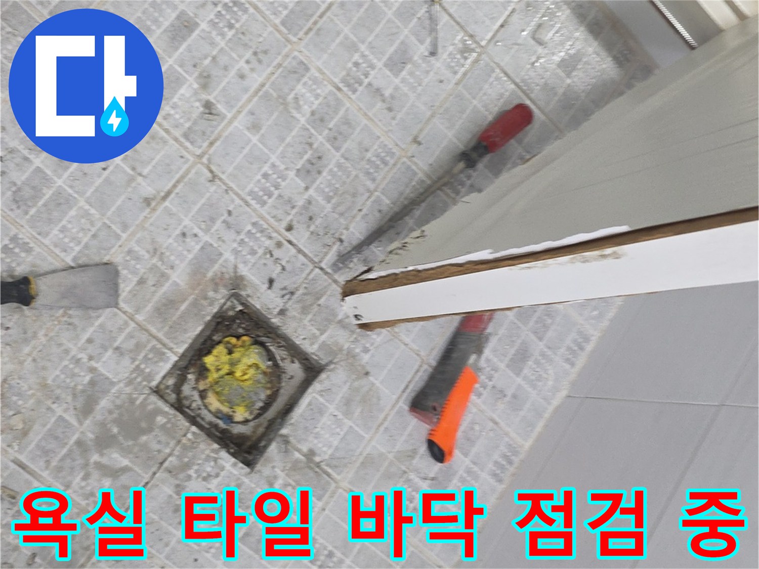 탈거된 변기 자리 근처의 배수구 유가와 작업 도구들