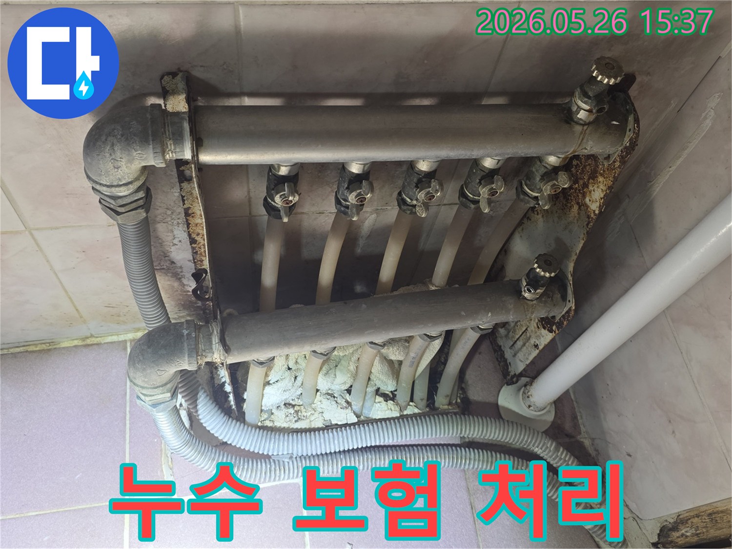 난방 분배기에서 발생한 누수 흔적과 심각한 부식 상태를 보여주며-보험 처리가 가능한 현장 이미지