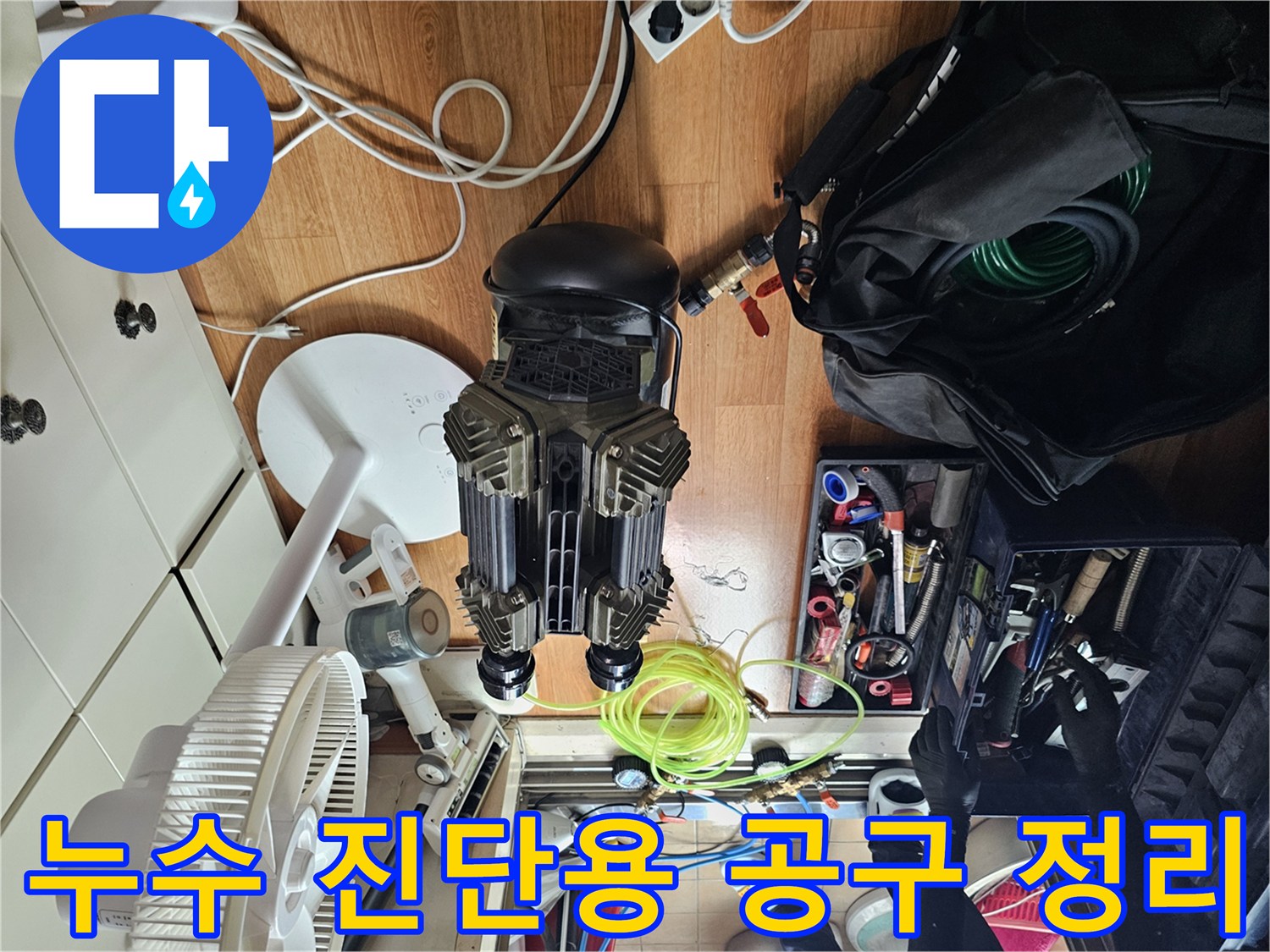 싱크대 하부 누수 지점을 찾기 위해 배치된 압력 측정 장비와 수리 도구들