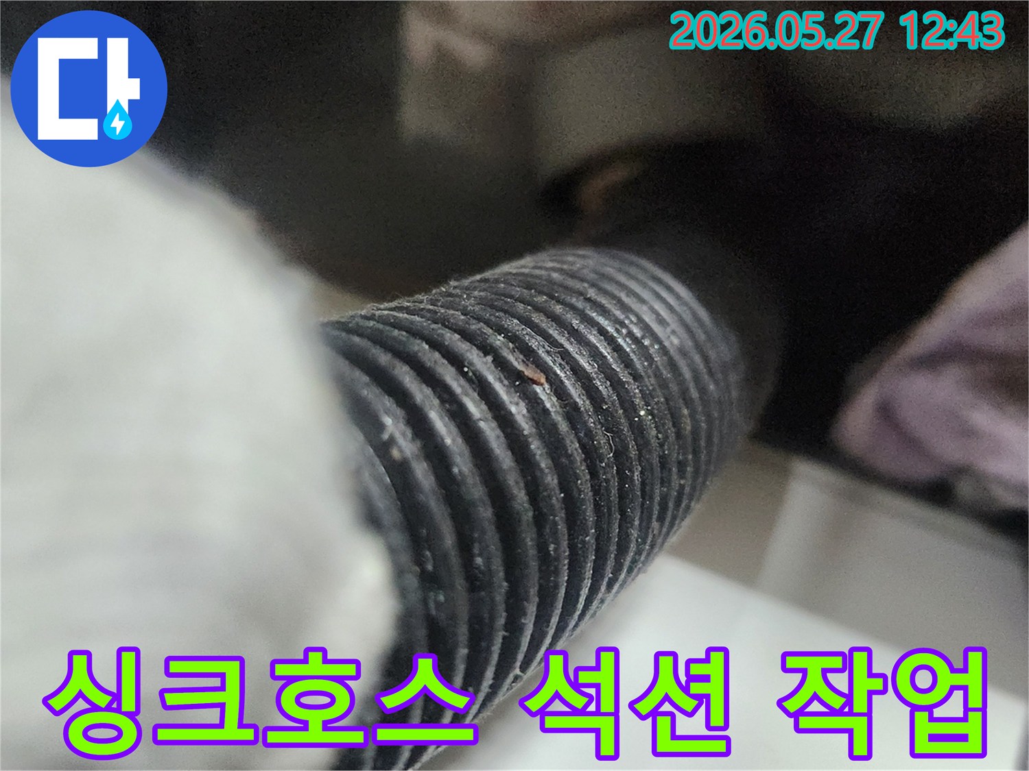 이 사진은 싱크대 배수 호스에서 석션 작업을 진행하는 모습을 보여줍니다-배관 내부의 이물질을 제거하여-막힘을 해결하는 중요한 과정입니다.