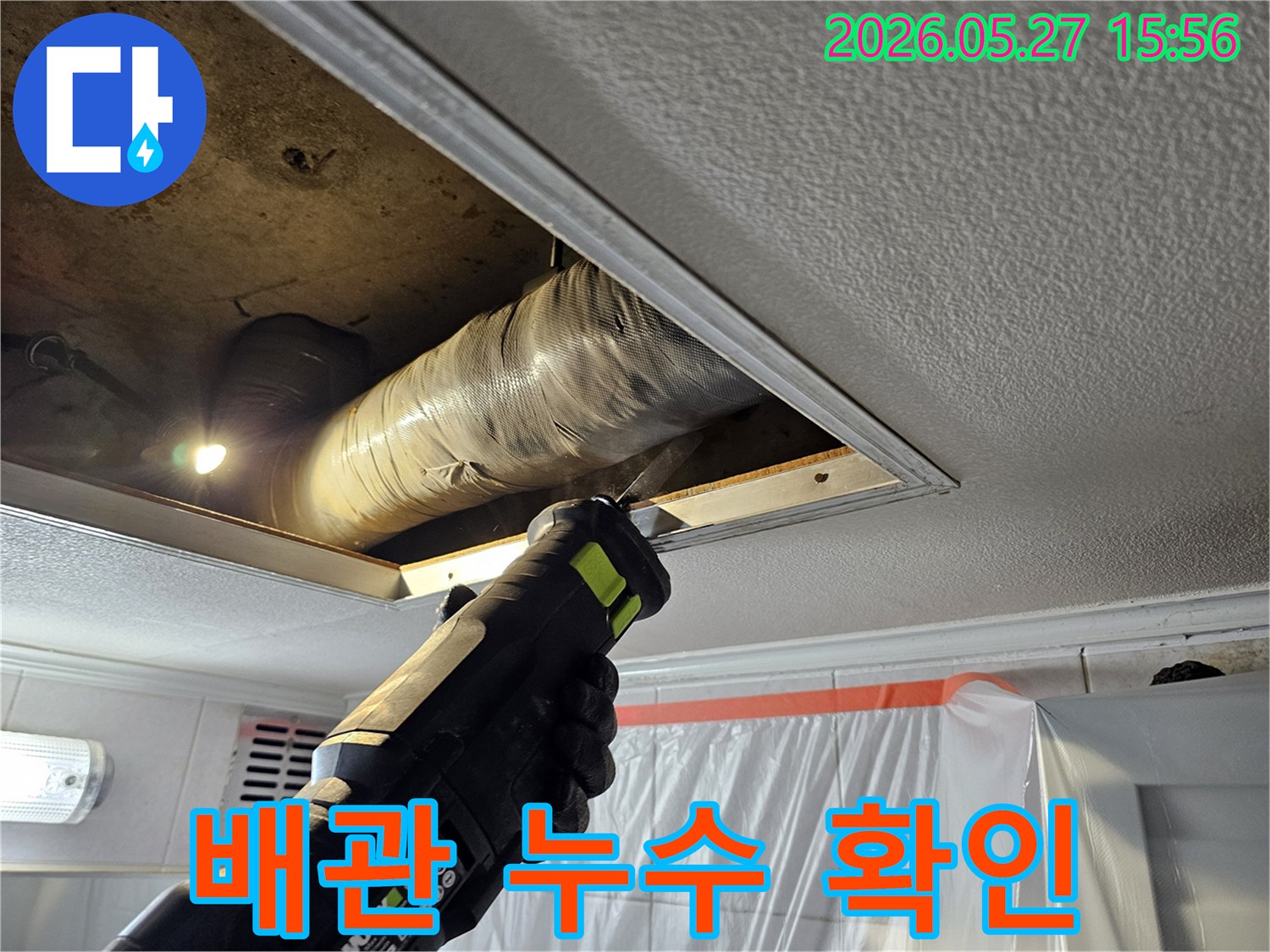 천장 누수 공사-현장에서-작업자가-전동톱을 이용해-천장 점검구를-확장하고-있습니다