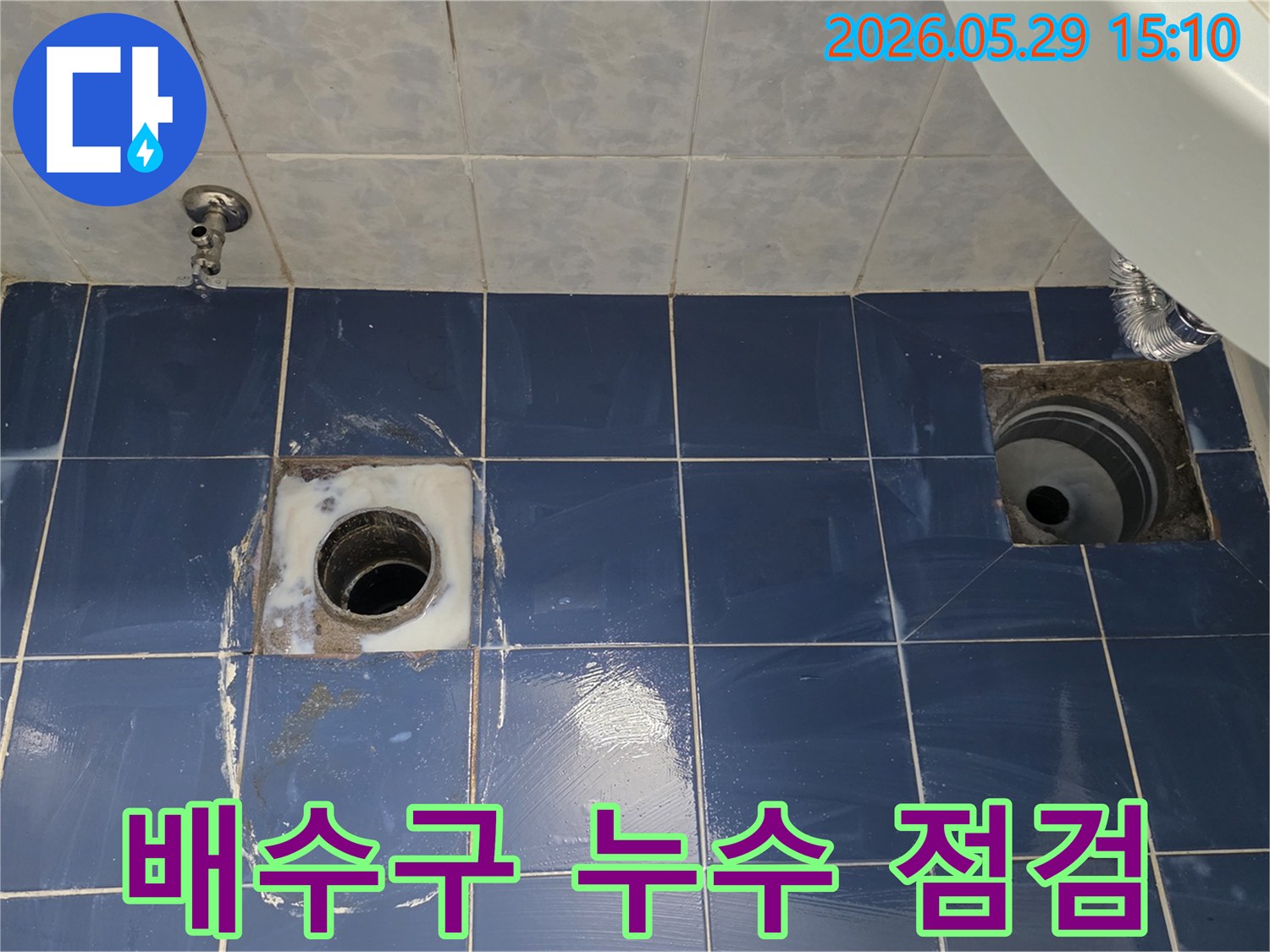 동두천 아파트 화장실 배수구 주변에서 누수가 발생하여-타일을 개방하고 배수관의 상태를 면밀히 점검하는-누수 탐지 및 공사 준비 현장의 모습입니다.