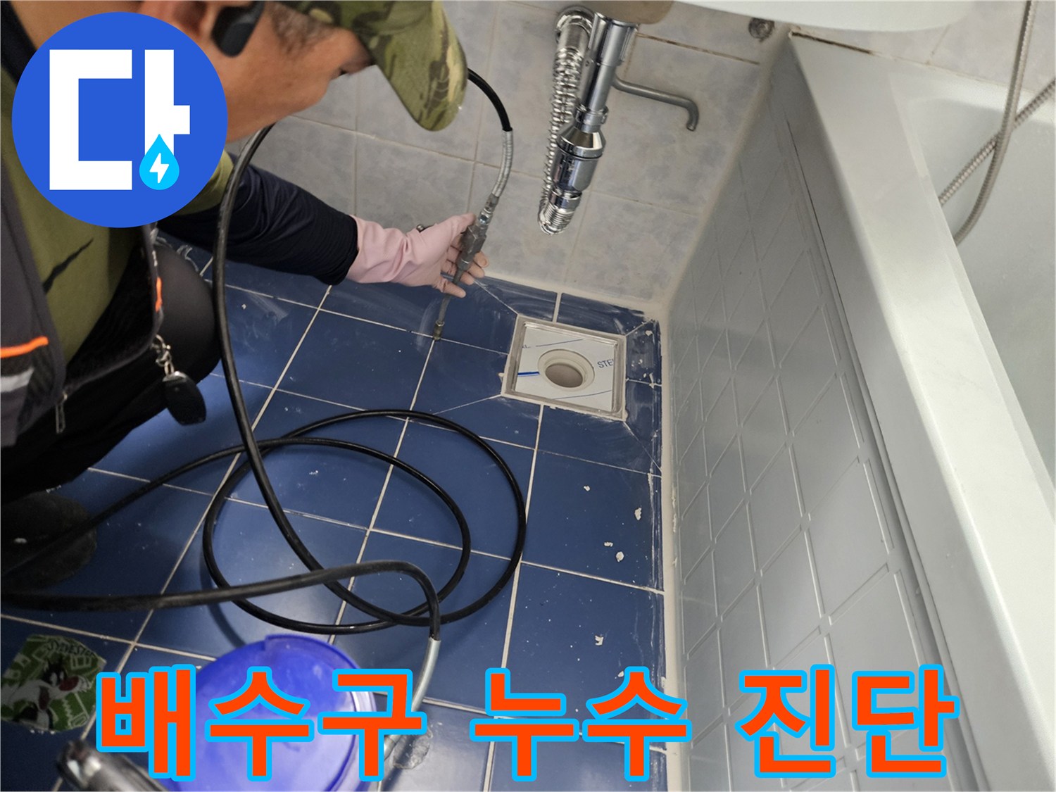 배수구 주변의 타일 상태와 배관 연결부를 점검하는 작업 현장