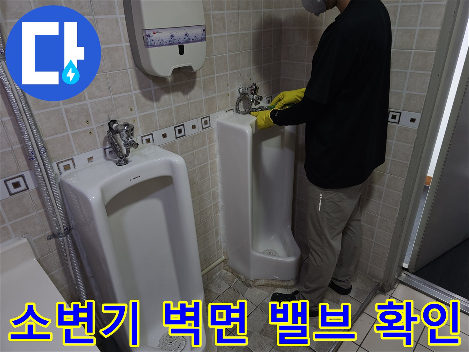 소변기 급수 부위의 연결 상태를 점검하는 전문가 작업 모습