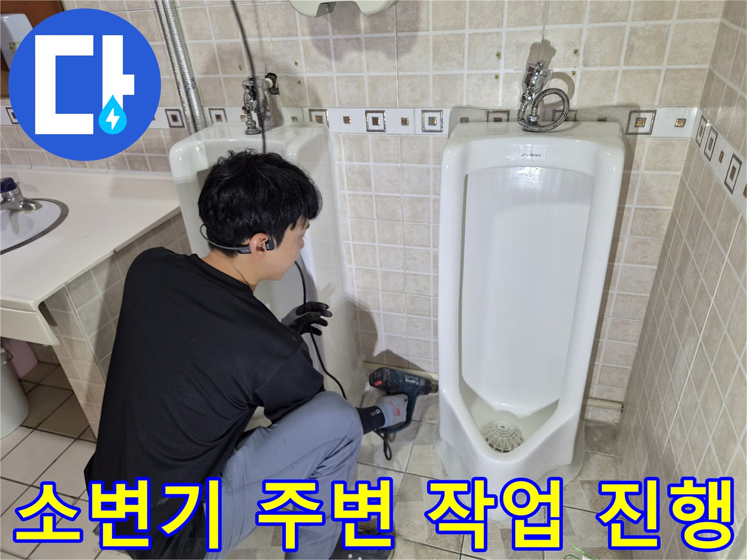 소변기 아래쪽 누수 지점을 찾아내기 위해 드릴로 점검하는 모습
