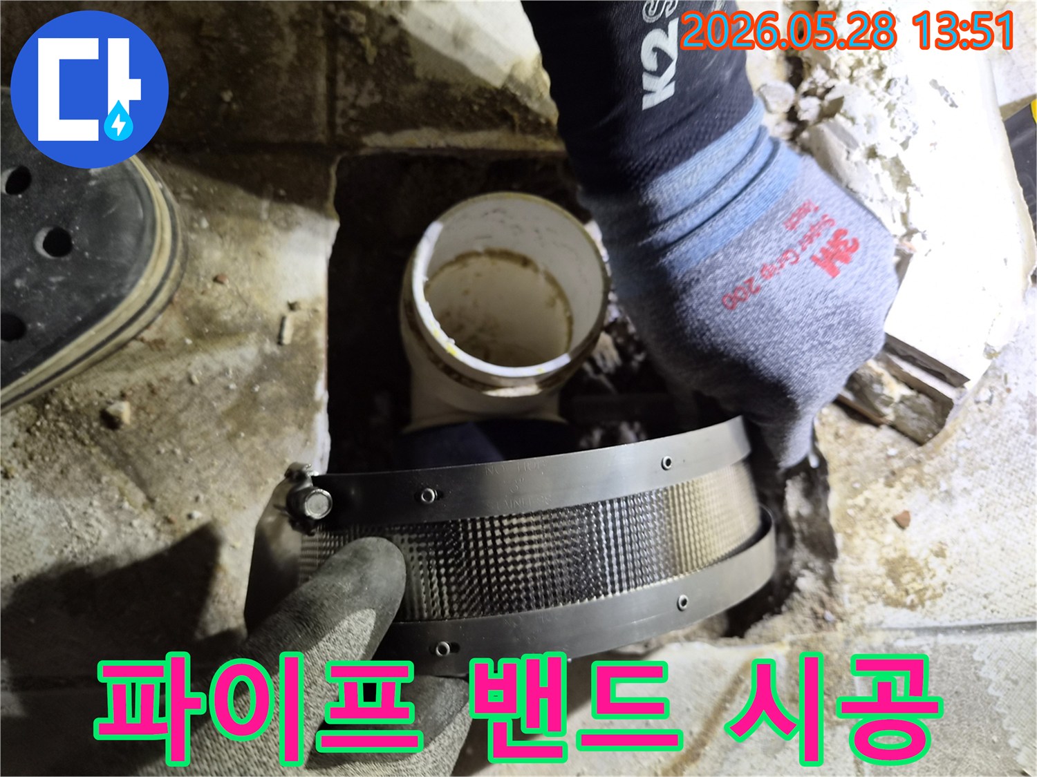 전문가가 작업용 장갑을 끼고-주택 배관의 누수 지점에-보수 밴드를 꼼꼼히 감는 중입니다