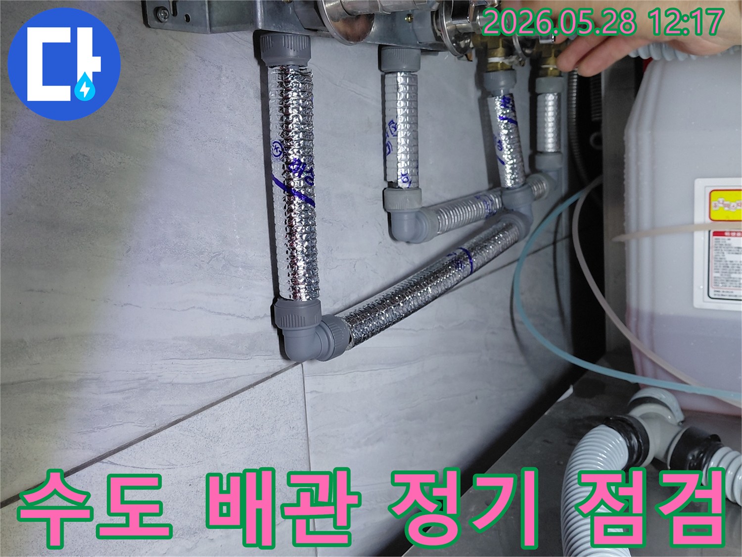 수도 배관의 밸브와 연결 부위를-전문가가 정기적으로 점검하며-누수 발생을 사전에 예방하는 모습