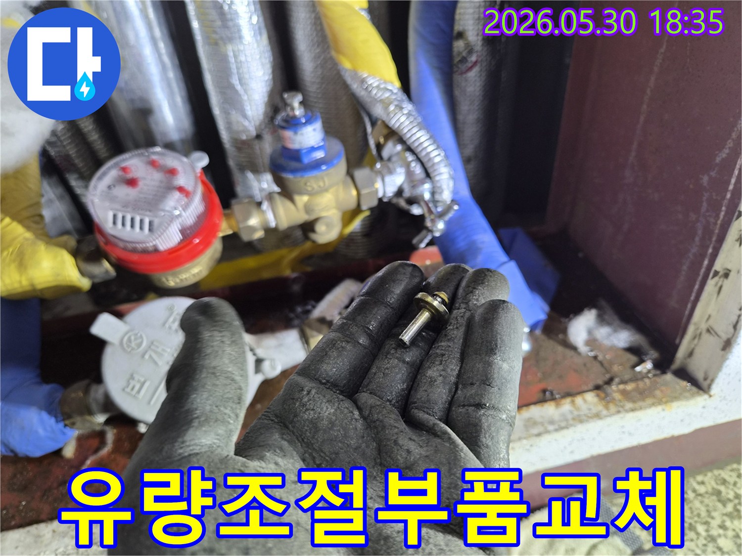 아파트-수도-계량기-내부-유량-조절-부품을-작업자가-교체하기-위해-들고-있는-장면