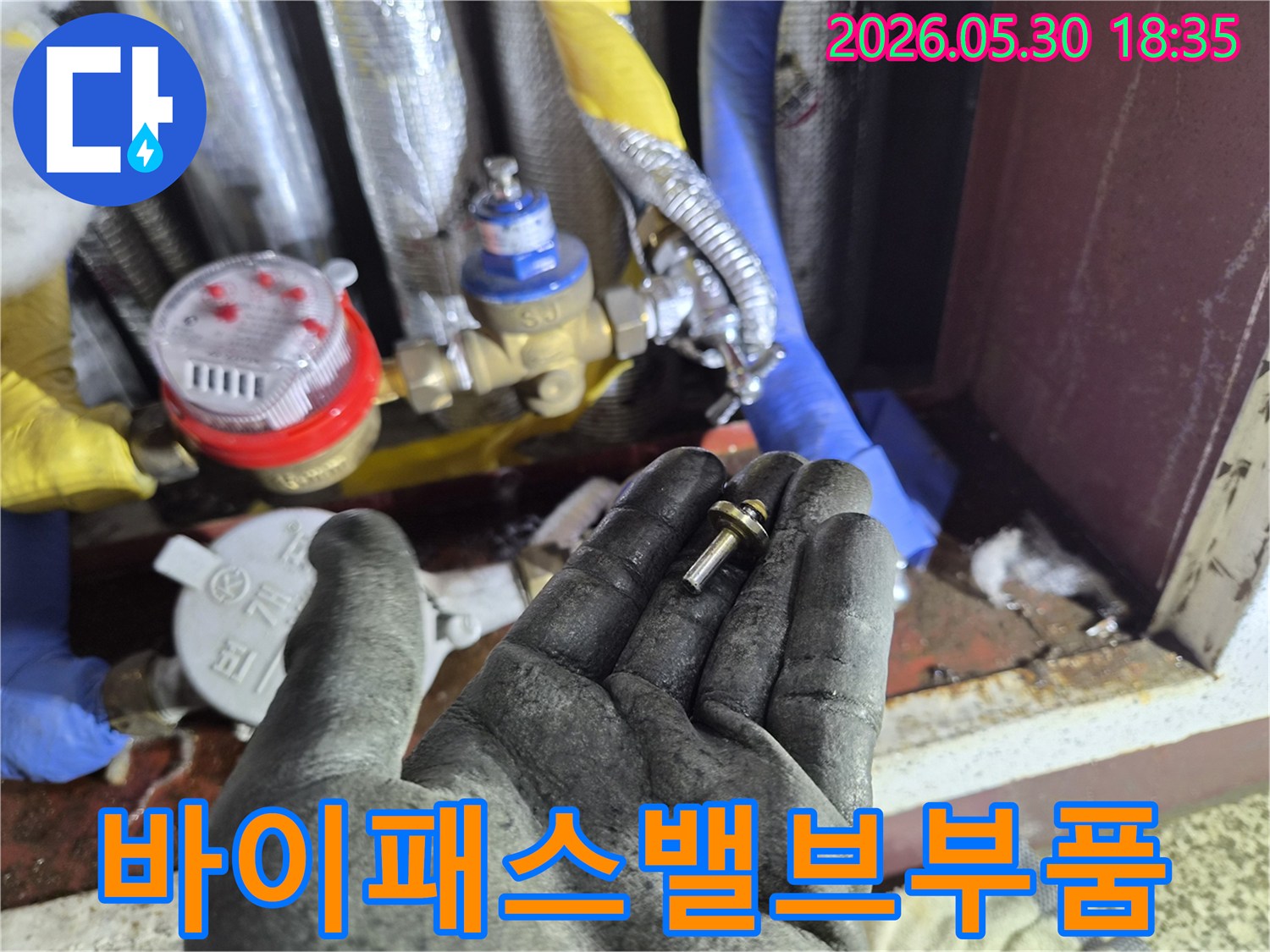 주택-수도-계량기-바이패스-밸브-누수-현장에서-발견된-손상된-부품을-작업자가-확인하는-모습