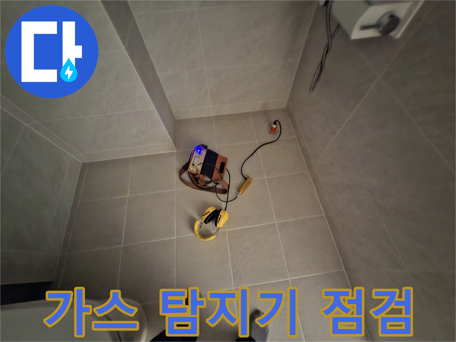 욕실 바닥에 놓인 가스 탐지 장비와 전선