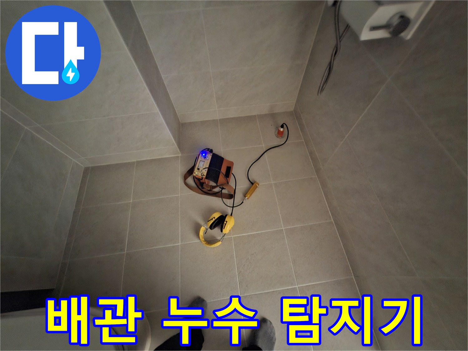 욕실 바닥에 놓인 노란색 가스식 누수 탐지 장비 세트