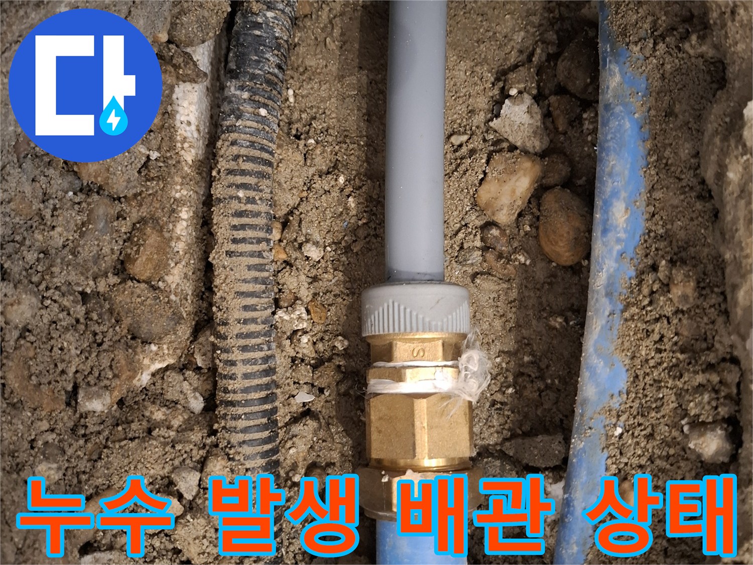 흙과 돌 사이로 보이는 파손된 온수 배관 및 금속 부속