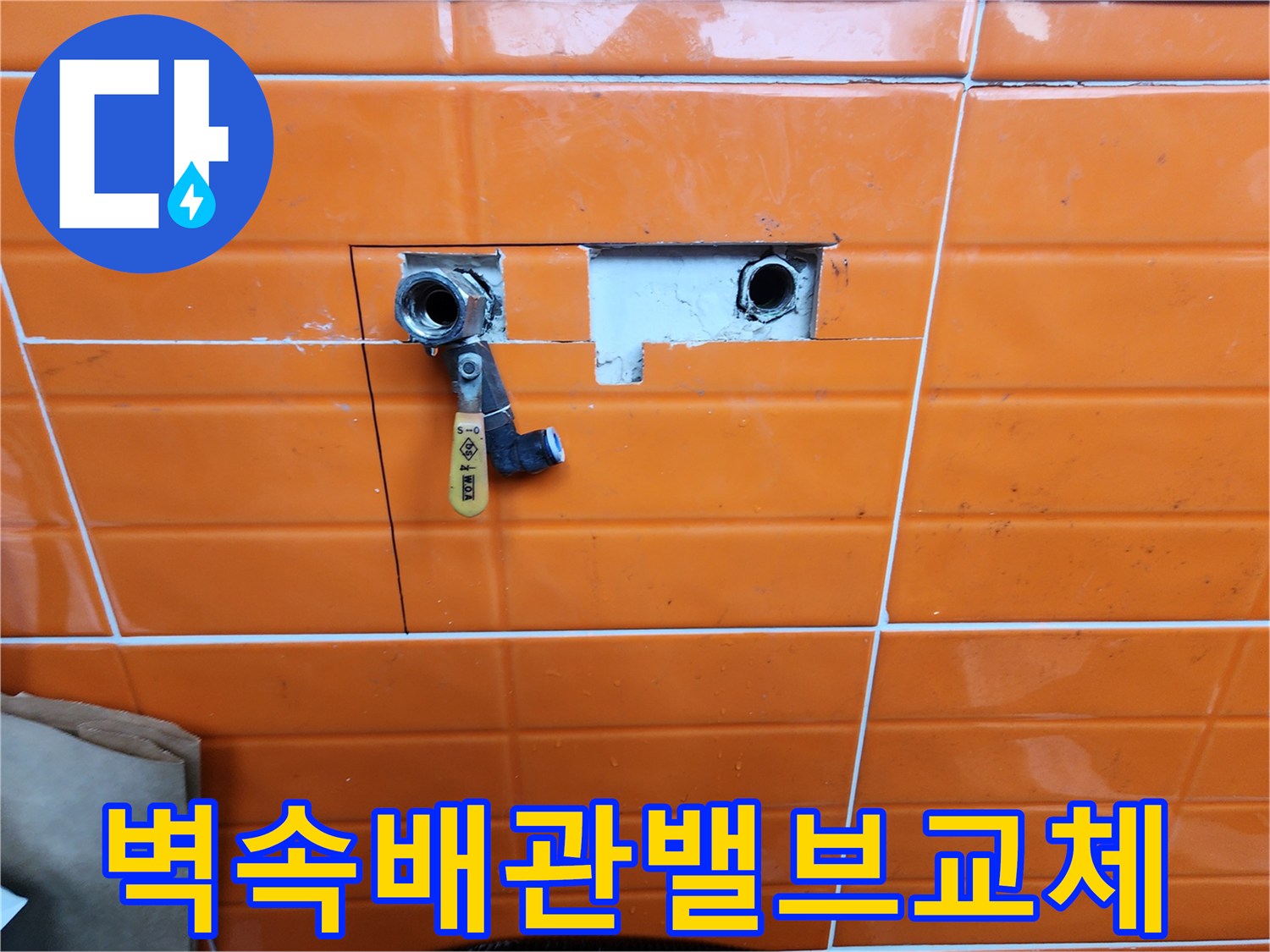 오렌지색-타일이-부분적으로-제거된-곳에-새로운-수도-밸브가-설치된-배관-수리-과정을-담은-사진입니다.