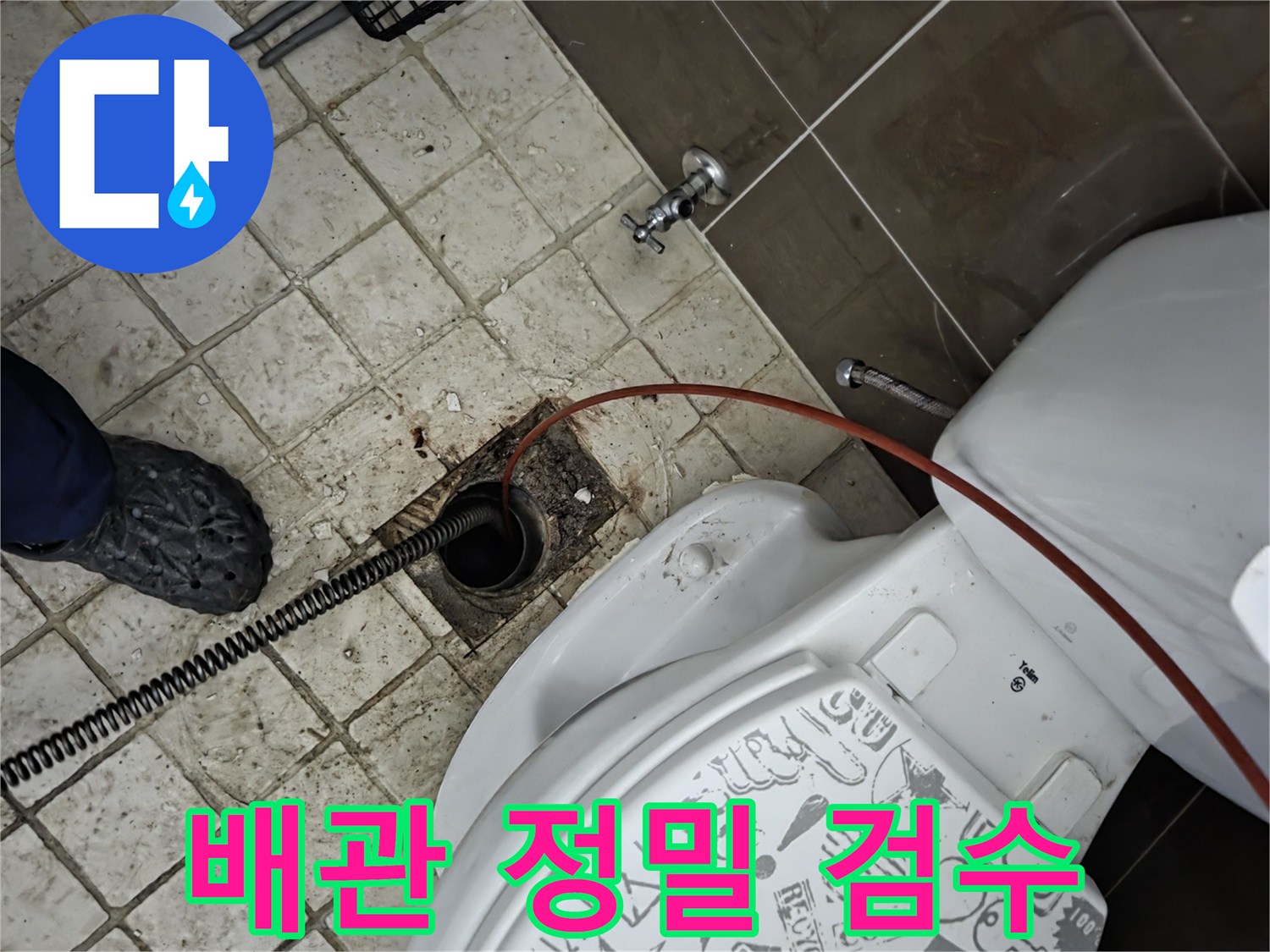 화장실 바닥 배수구에-내시경과-스프링 장비가-삽입되어-배관 내부를-정밀하게-검수하는-전문가의-작업 모습