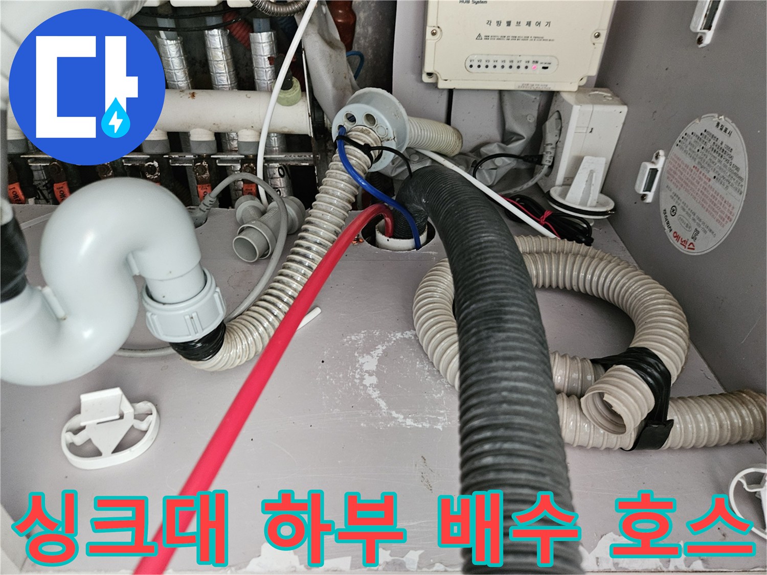 싱크대 아래쪽의 굵은 주름관과 흰색 연결 부위 근접 사진