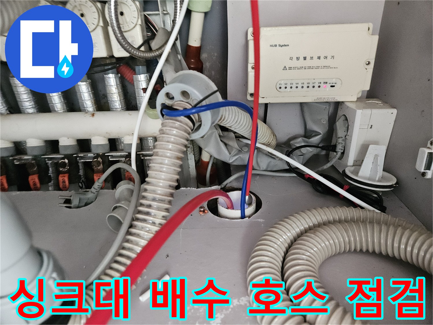 싱크대 하단 유틸리티 박스와 굴곡진 배수 호스의 연결 상태