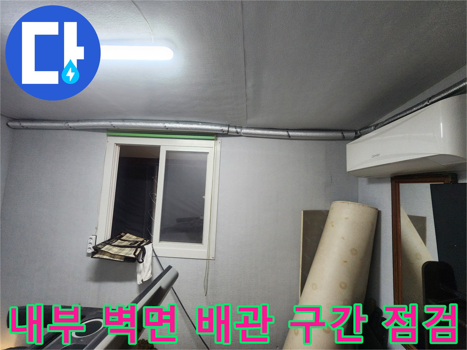 창문 근처 노출된 수도 배관의 상태를 정밀하게 파악하는 작업 현장