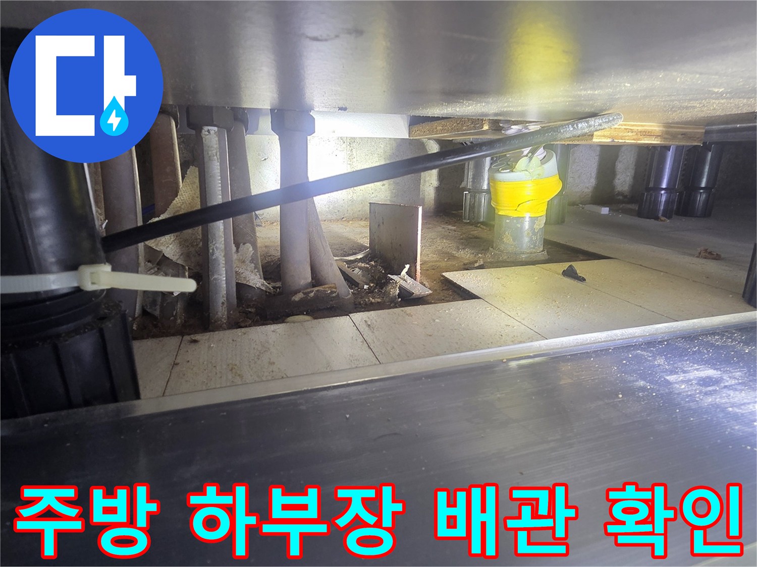 싱크대 아래 복잡한 배관 구조와 연결 부품들을 근접 촬영한 이미지