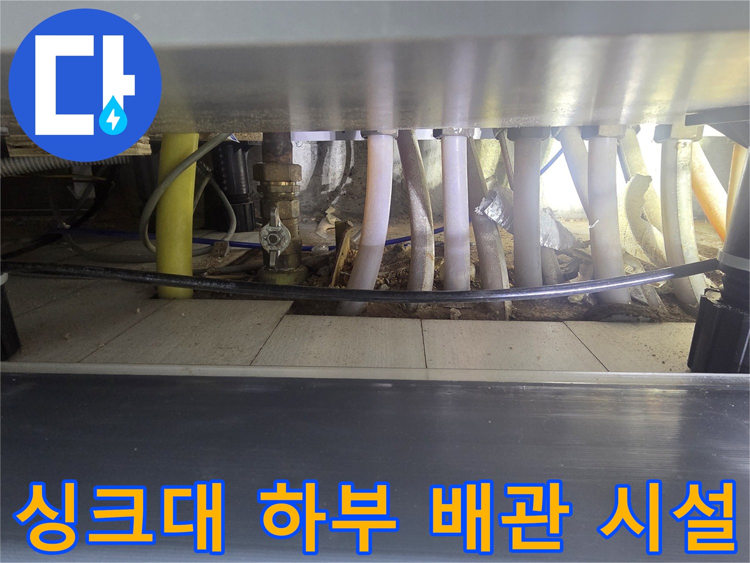 싱크대-하부-공간의-보일러-분배기와-다양한-연결-관들