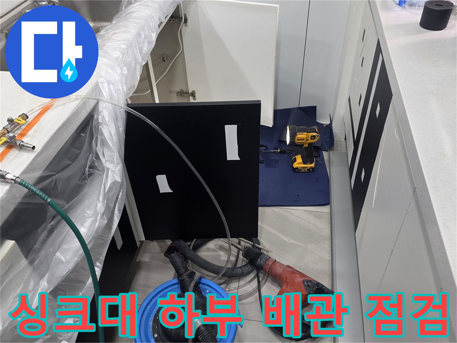 싱크대 아래쪽 배관에 연결된 압력계와 검사용 호스 장비