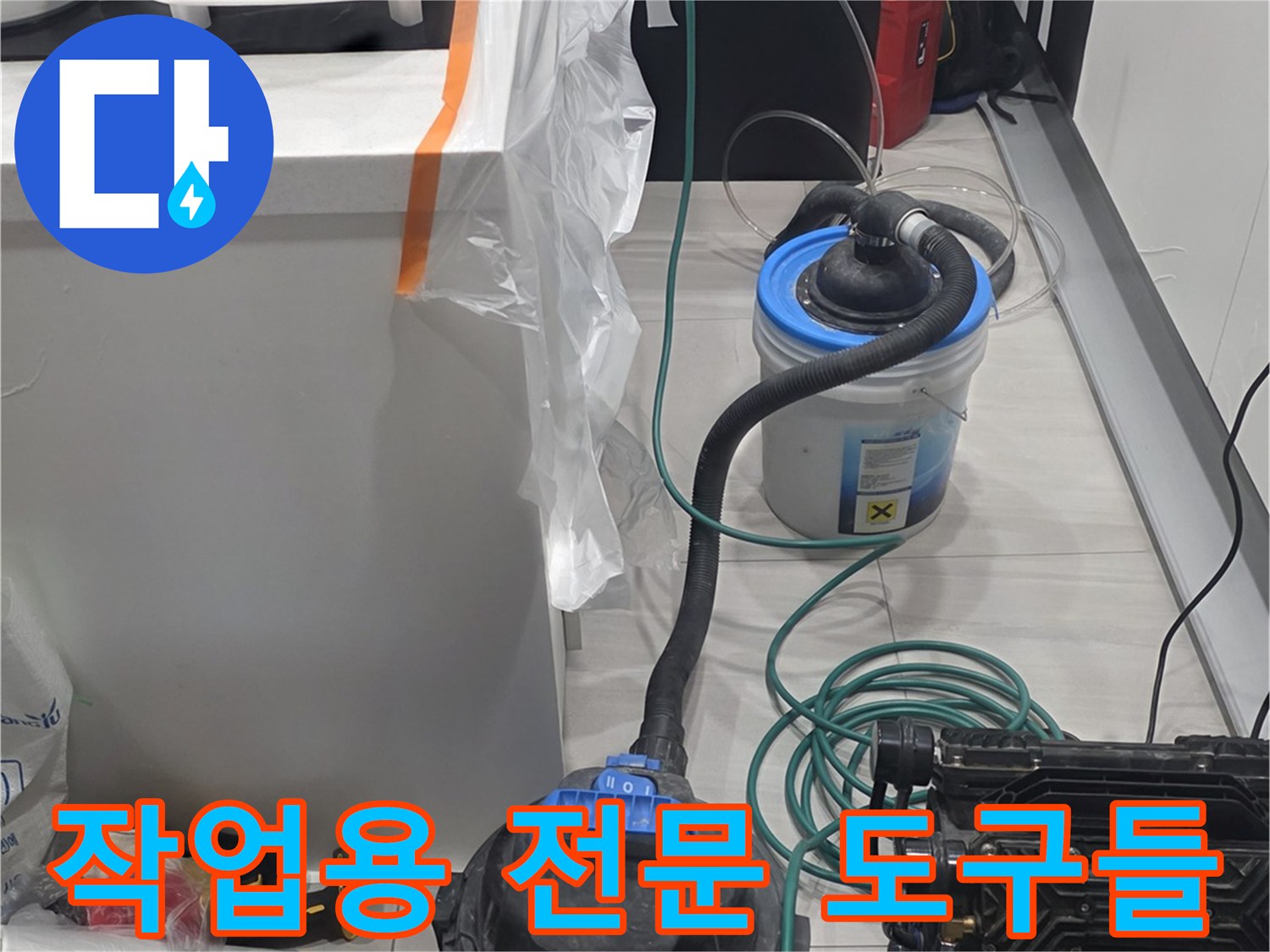 싱크대 하부 작업 공간에 정렬된 배관 점검용 장비