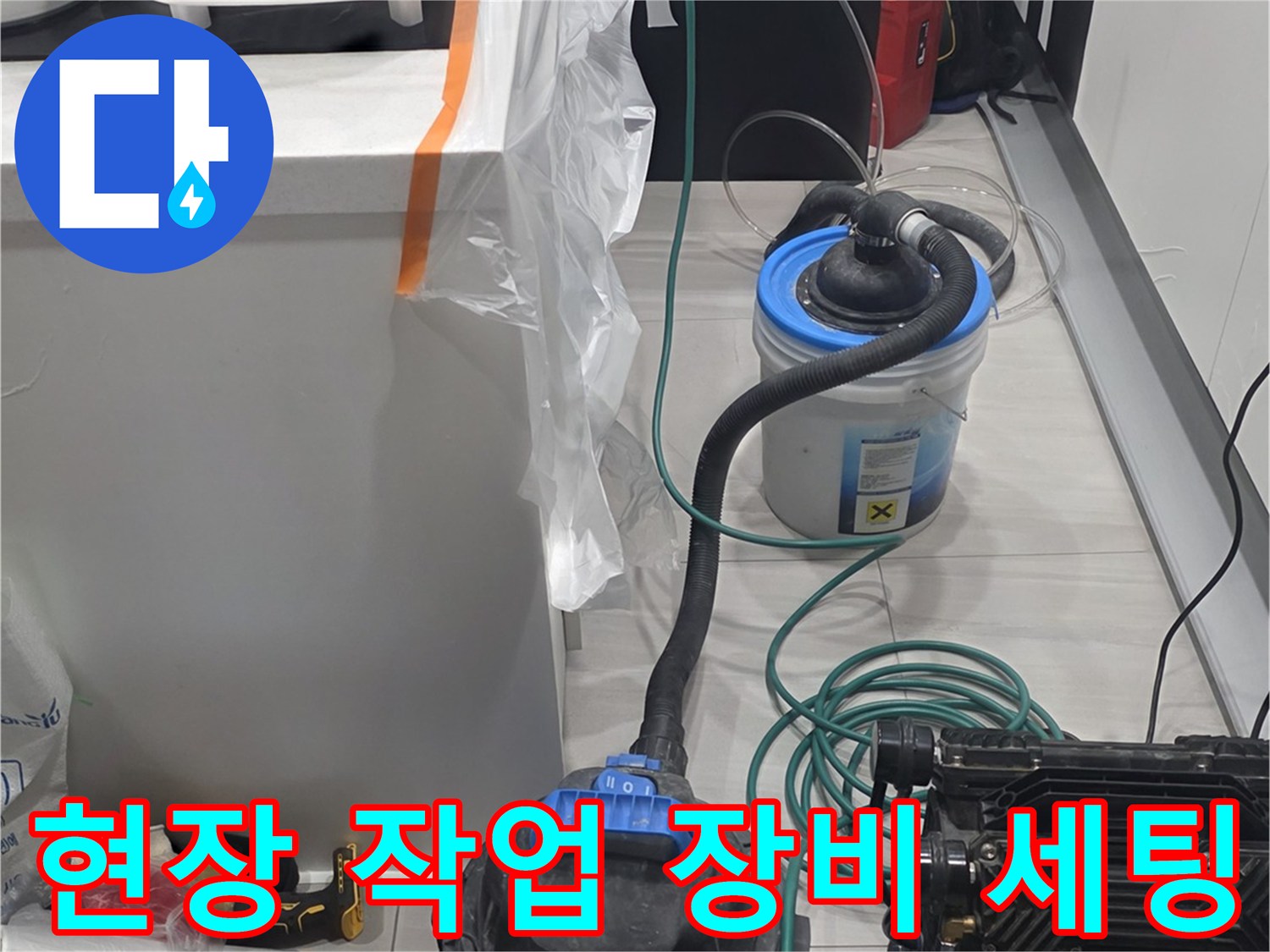 싱크대 하부장 근처에 배치된 누수 탐지용 전문 장비와 청소 도구