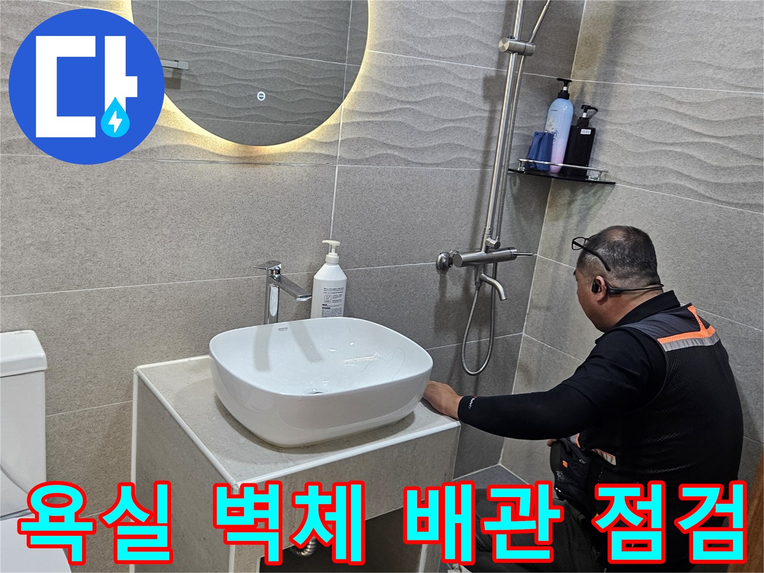 세면대 하단부 타일 부근에서 배관의 이상 유무를 진찰하고 있습니다.