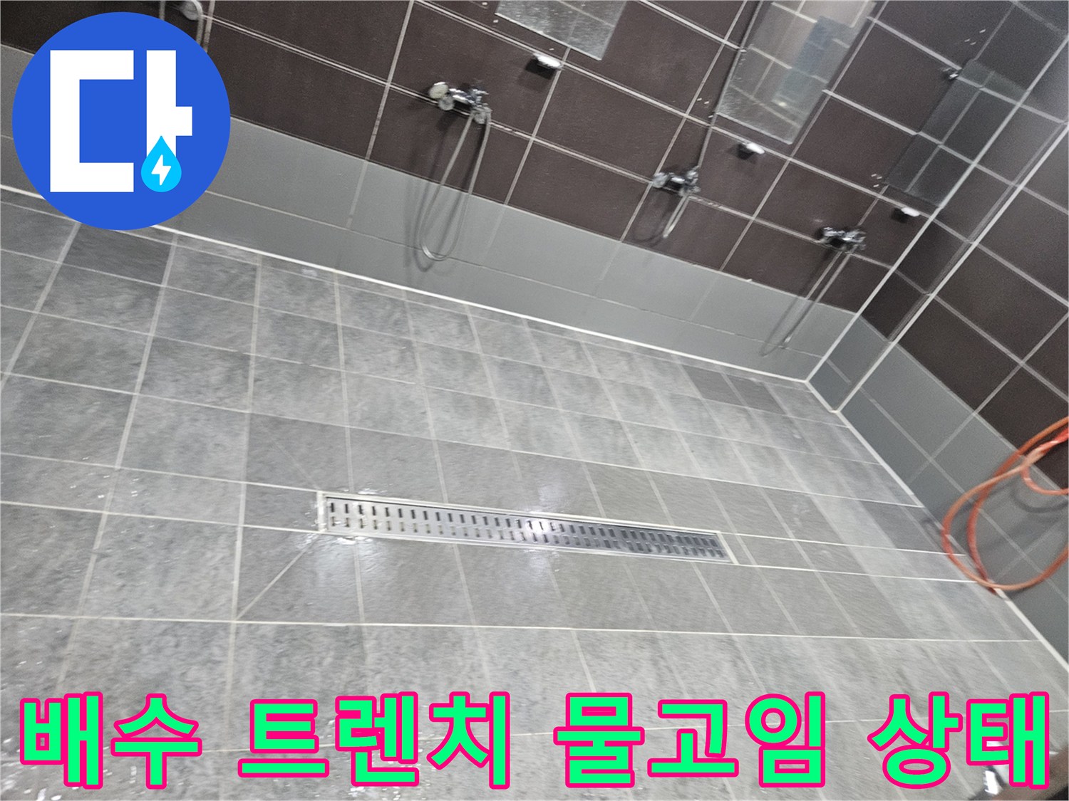 물기가 고인 샤워실 배수구-타일 사이의 물샘 현상을 보여주는 사진입니다.