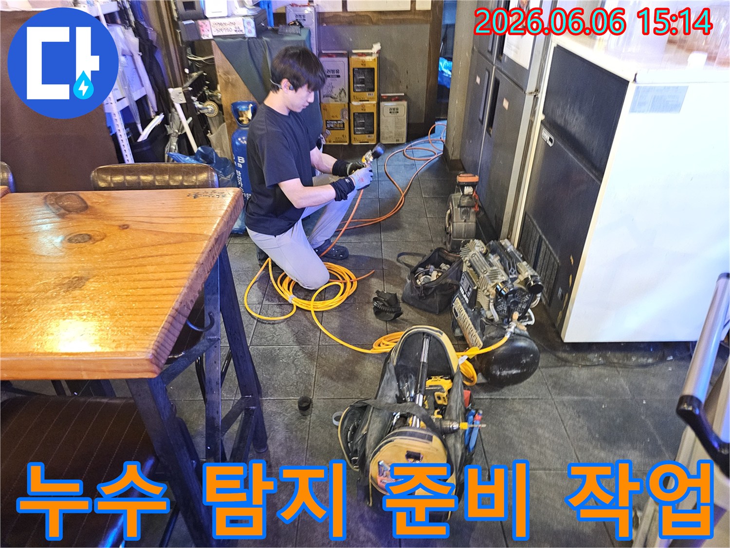 누수 전문 기술자가-카페 내부에서-탐지 장비를 꼼꼼히 연결하고 있습니다.