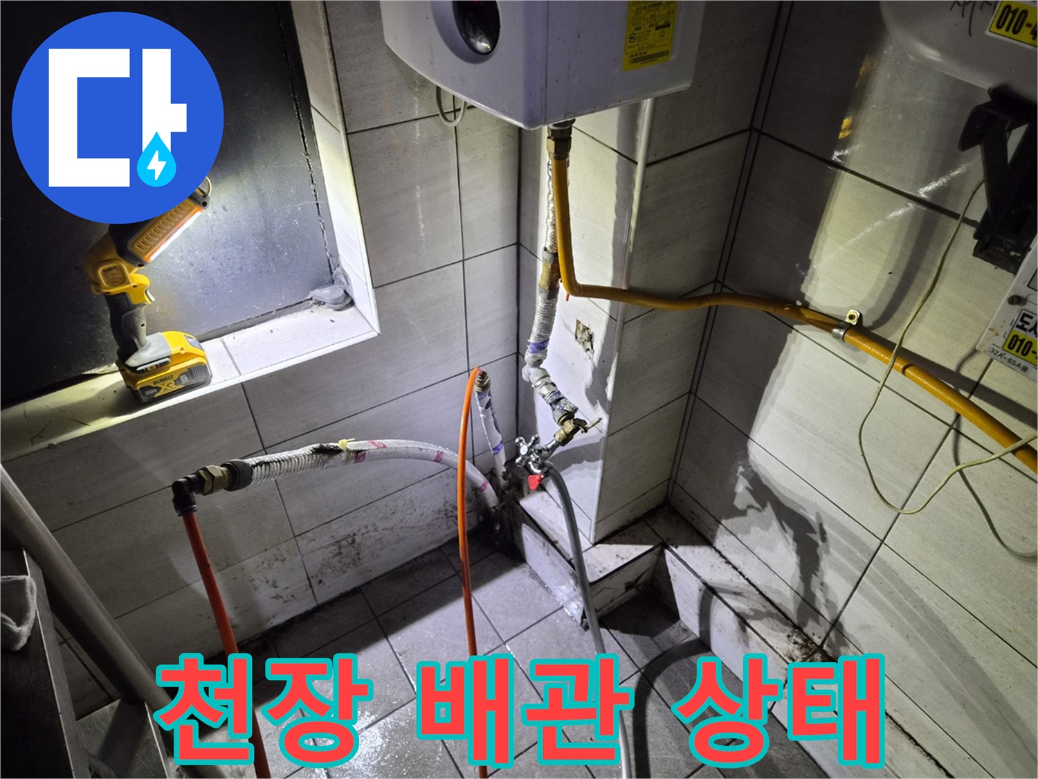 천장 내부 타일 벽면과 노란색 배관 및 작업용 전동 드릴