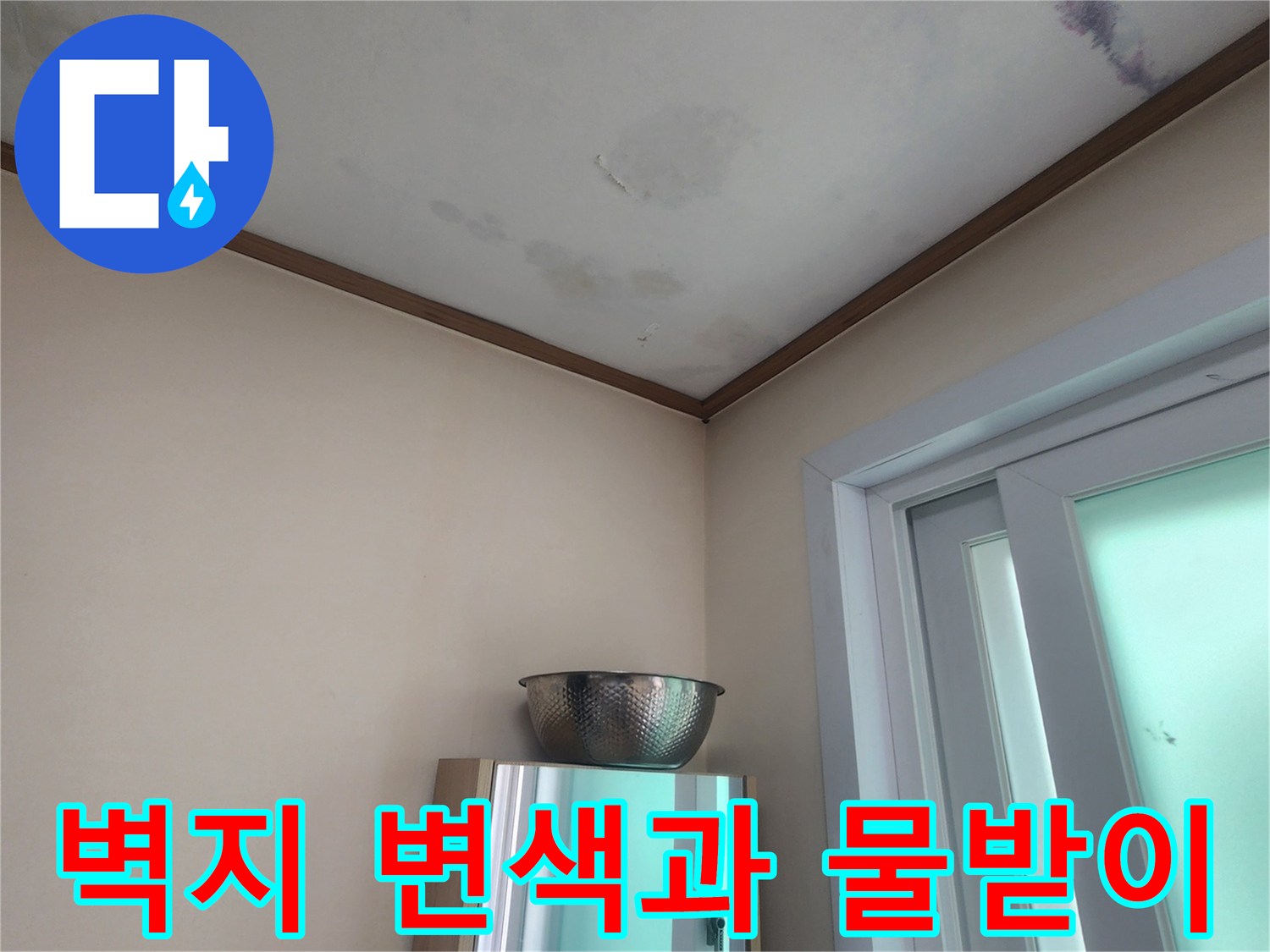 누수로 인해 벽지가 젖어있고-물이 떨어지는 것을 막기 위해-설치된 임시 물받이