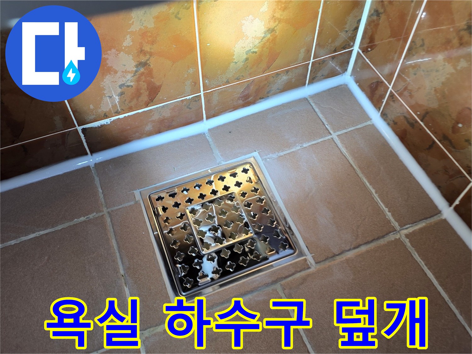 금속 소재의 배수구 유가와 주변 타일 시공 면을 촬영한 사진입니다.