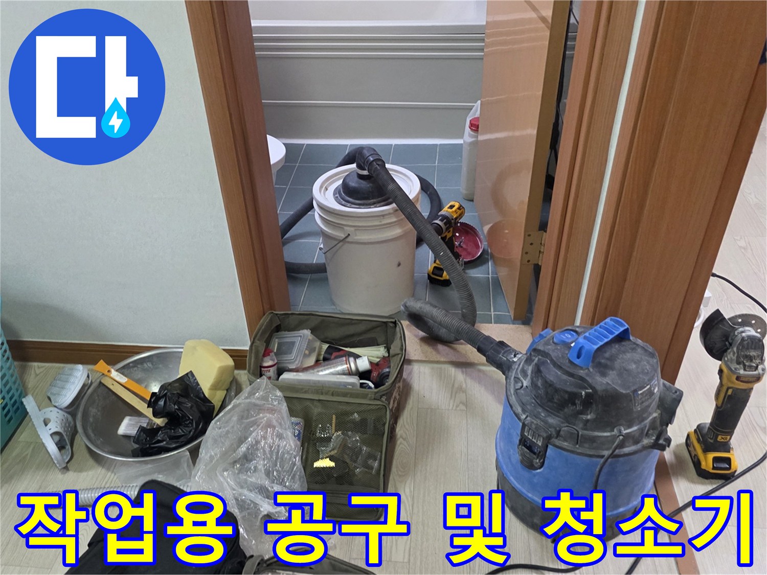 배관 점검 현장에 놓인 산업용 청소기와 바구니