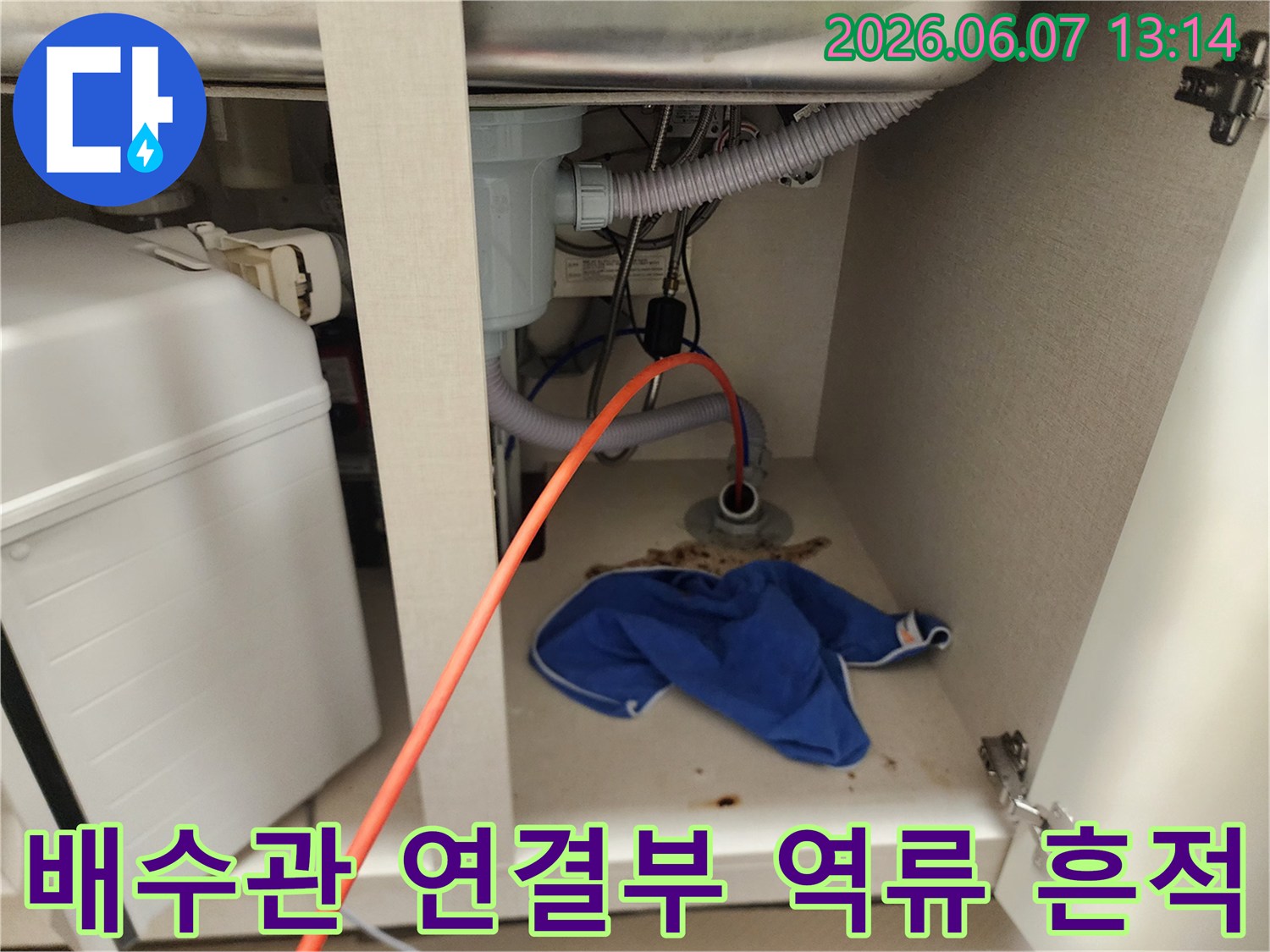 싱크대 배수 호스 주변 바닥에 역류한 이물질과 오염된 걸레가 보입니다.