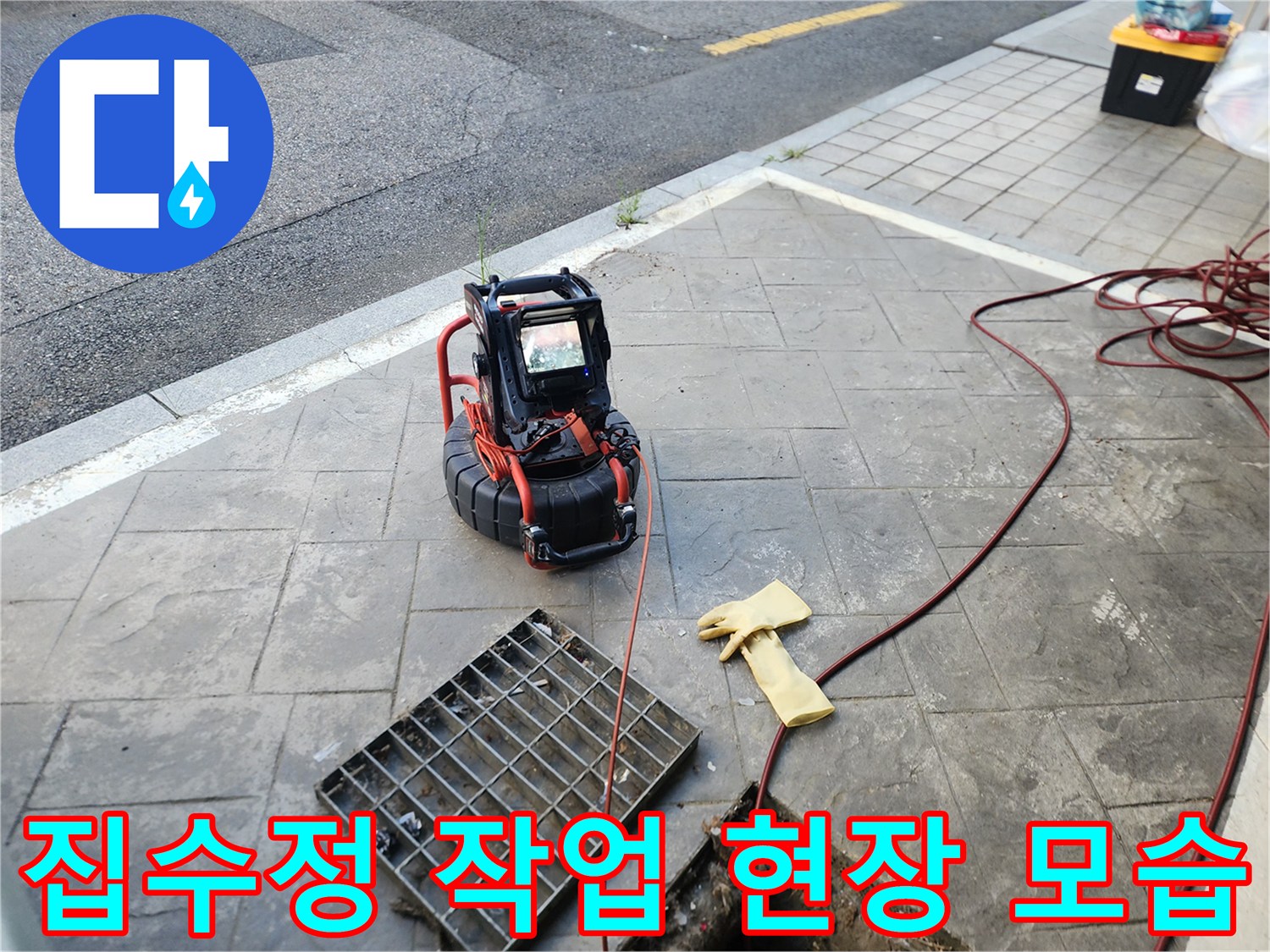 바닥 맨홀 근처의 배관 내시경 장비와 작업용 장갑