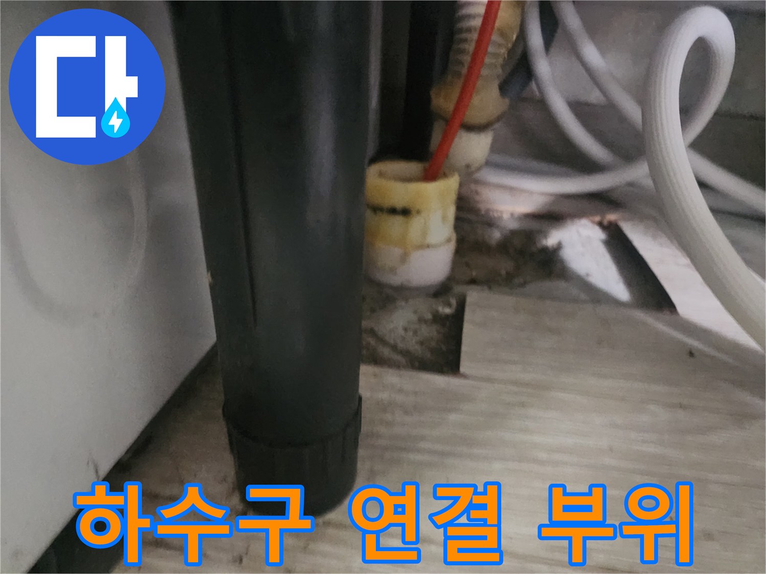 싱크대 하단 배수 호스와 노란색 소켓