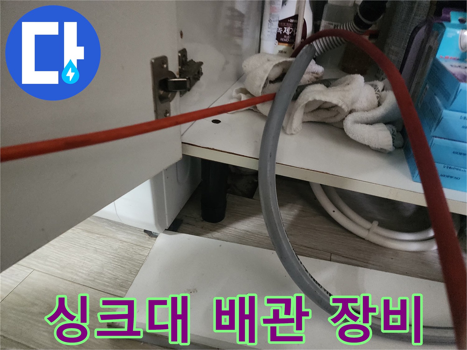 싱크대 하부장 내부의 배관 점검용 장비와 호스