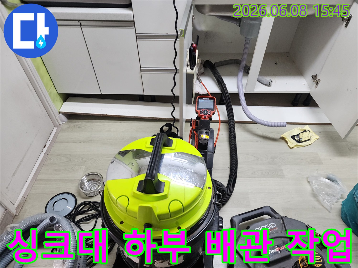 싱크대 밑 배수관 주변에 배치된 석션기와 청소용 장비들