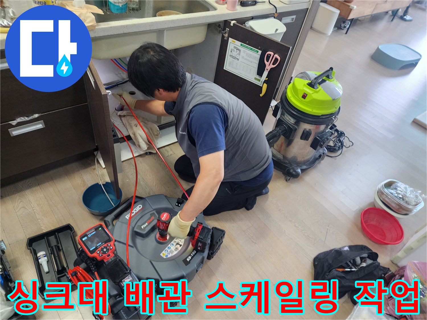 싱크대 하단 배관 내부의 기름 슬러지를 제거하기 위해 전문 스케일링 장비를 사용하는 모습