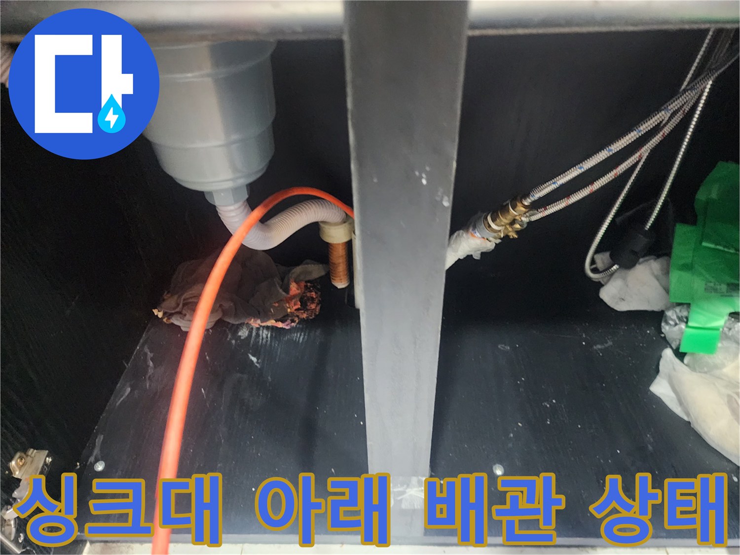 주황색-호스와 금속 밸브가 연결된 싱크대 하부 배관 구조