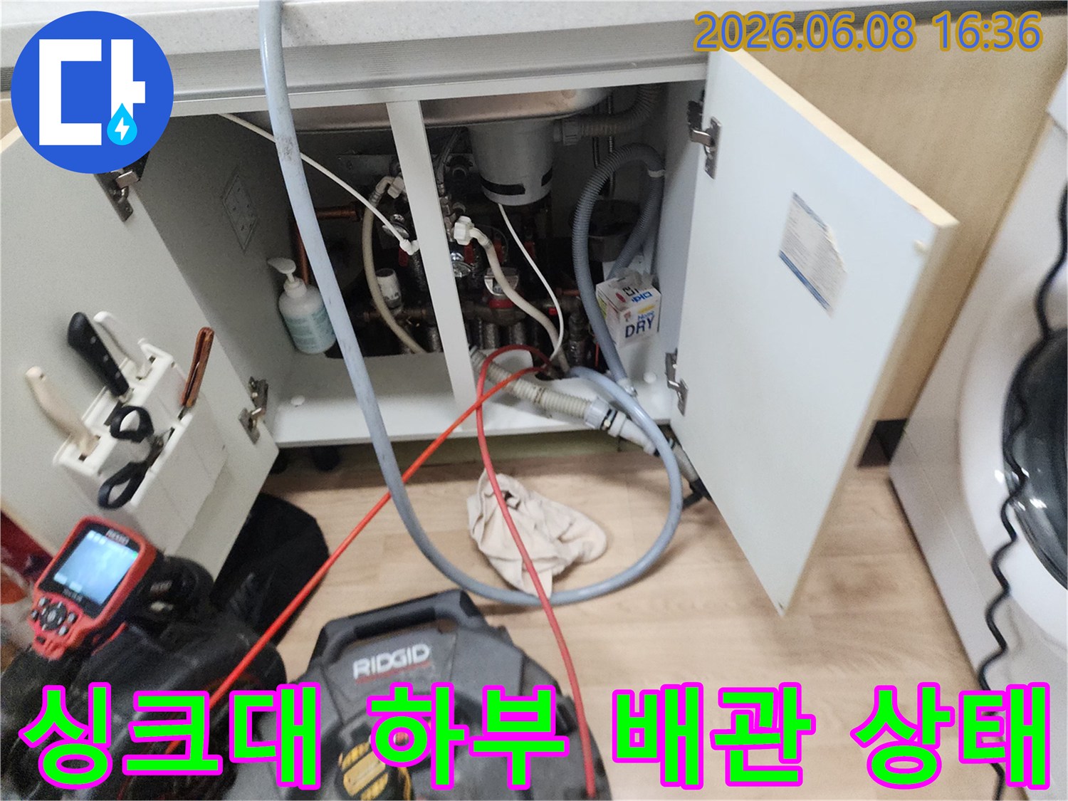 복잡한 구조의 싱크대 하단 배관과 작업용 케이블 연결 상태