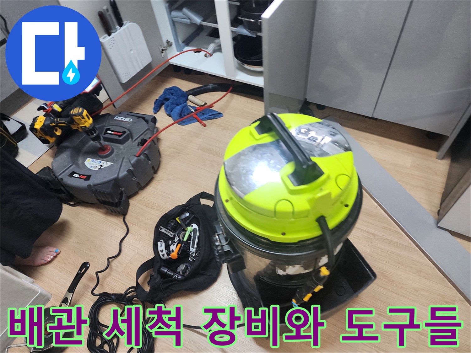 싱크대 아래 작업 공간에 놓인 배관 스케일링 및 흡입 전문 장비
