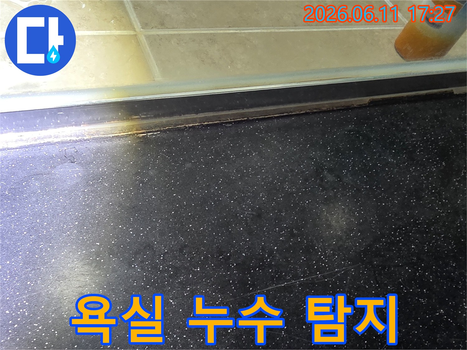 욕실 샤워부스 하단-타일 경계면의 누수 지점을 정밀 탐지한 후 촬영된 사진
