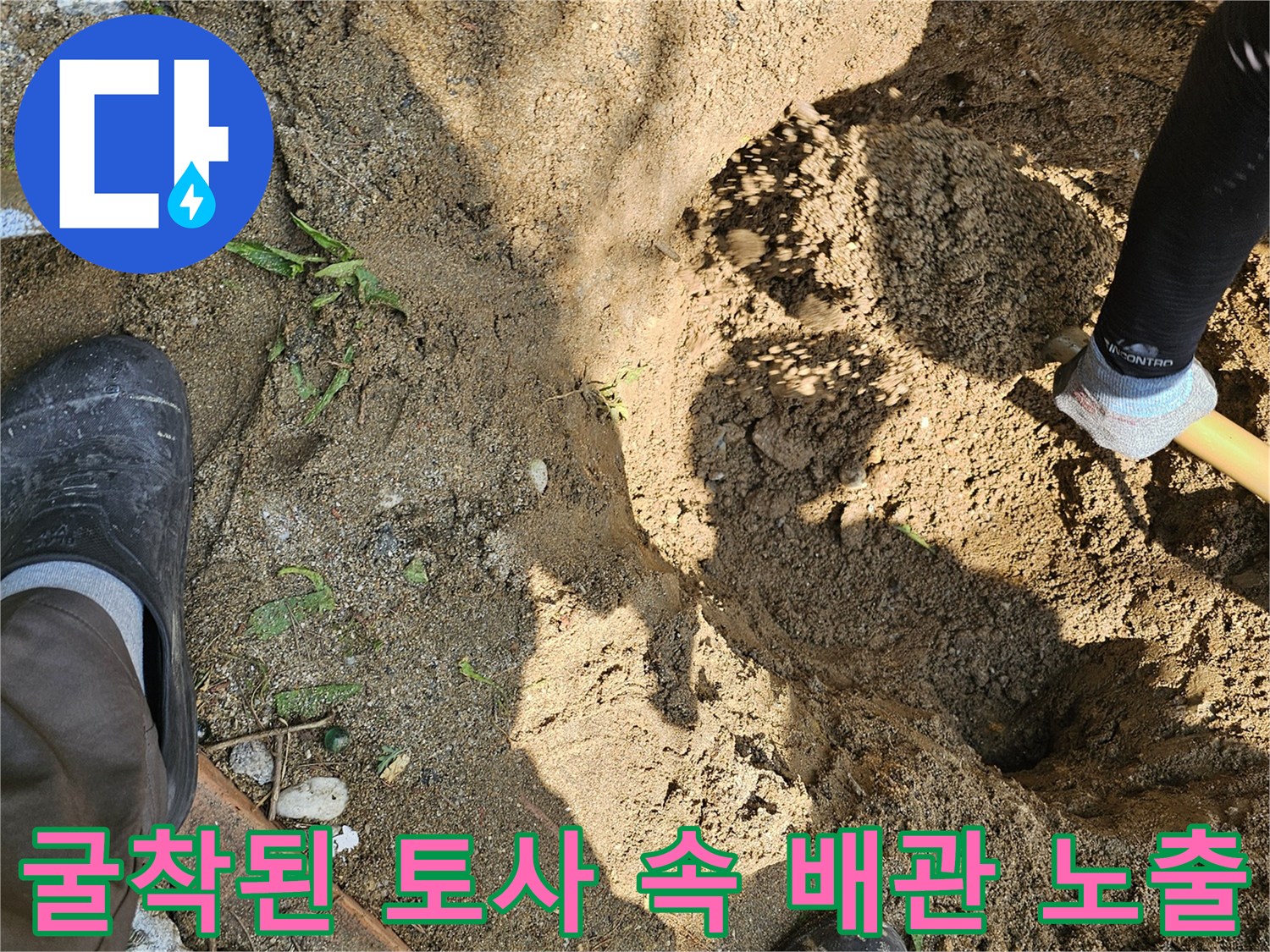 굴착 현장에서 작업자가 직접 파낸 흙 사이로 드러난 매립 배관의 모습
