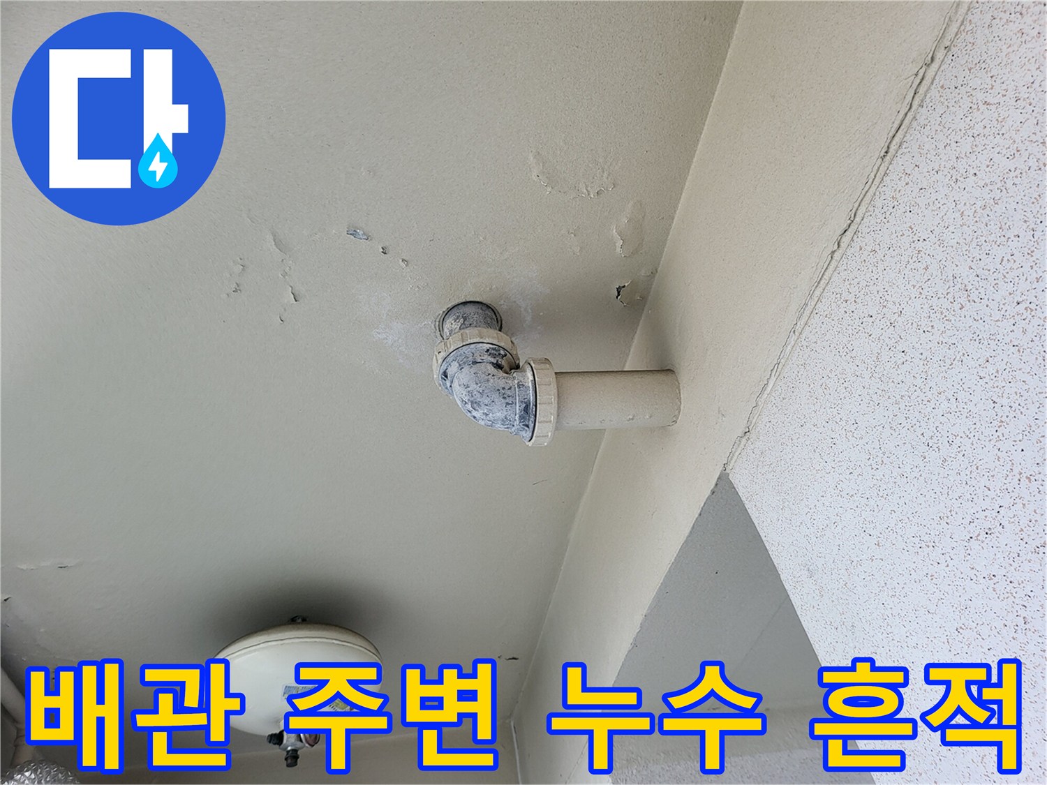 천장 배관 연결 부위 근처에 나타난 젖은 얼룩과 변색된 도장면
