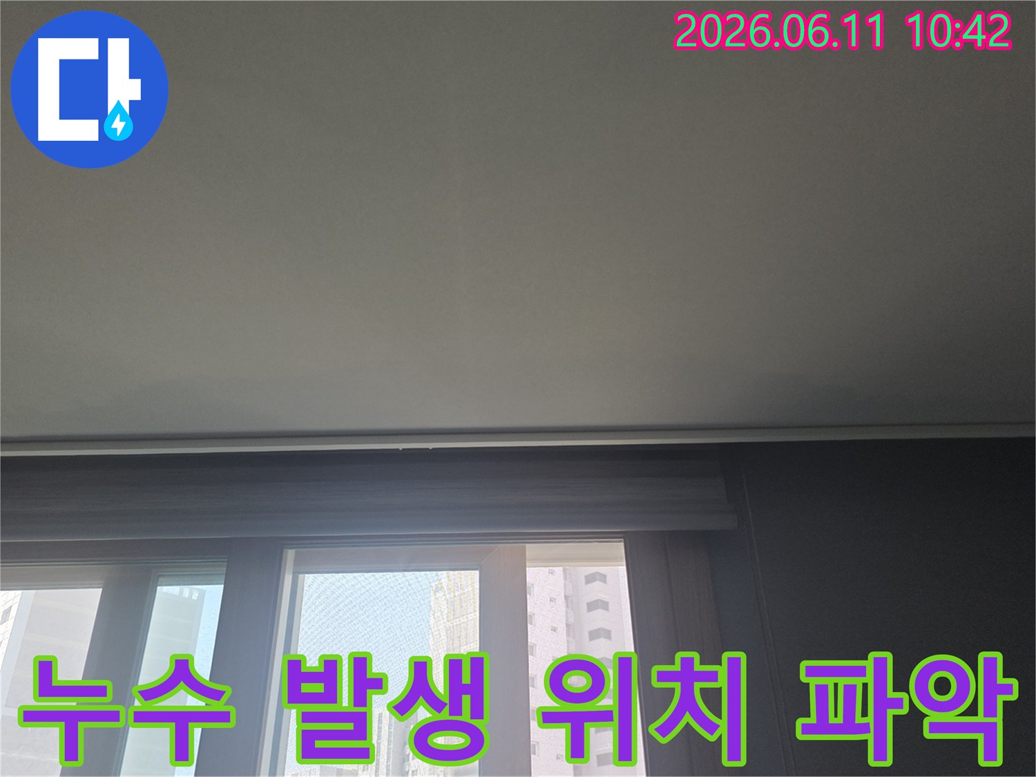 누수 발생 지점을 정확히 파악하기 위해-아파트 천장과 창문 주변을-면밀히 살펴보는 사진입니다.