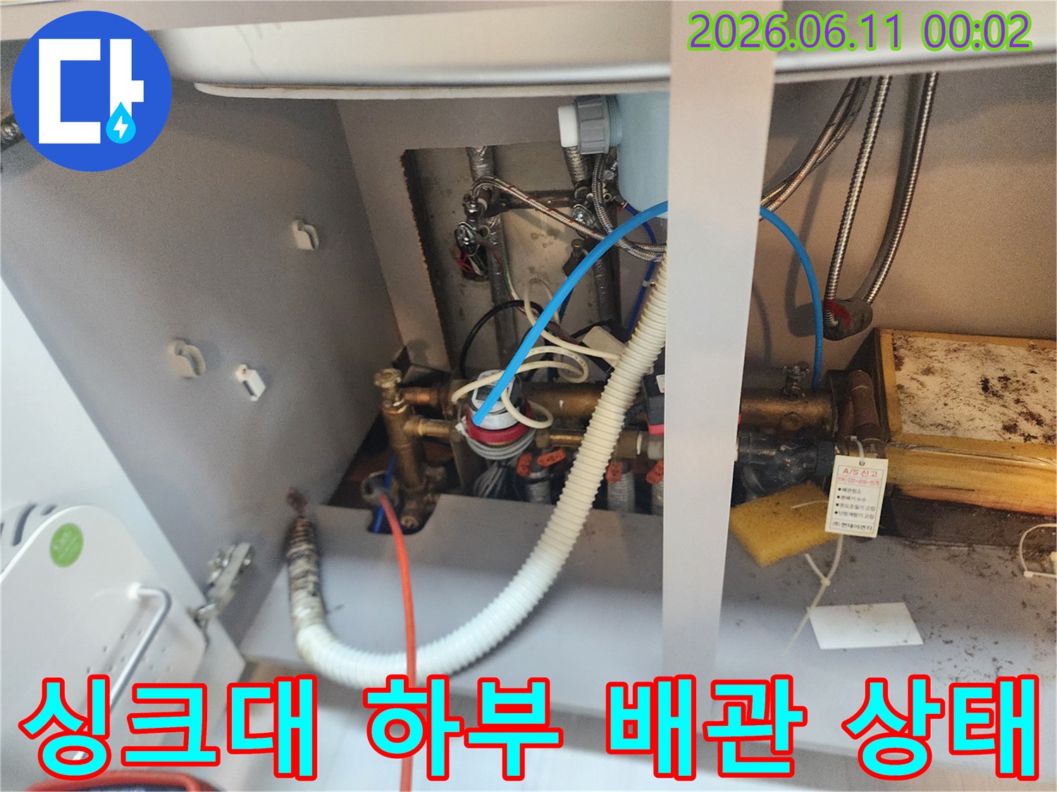 싱크대 하부장 내부-복잡하게 연결된 급수 밸브와 배수 호스 상세 촬영